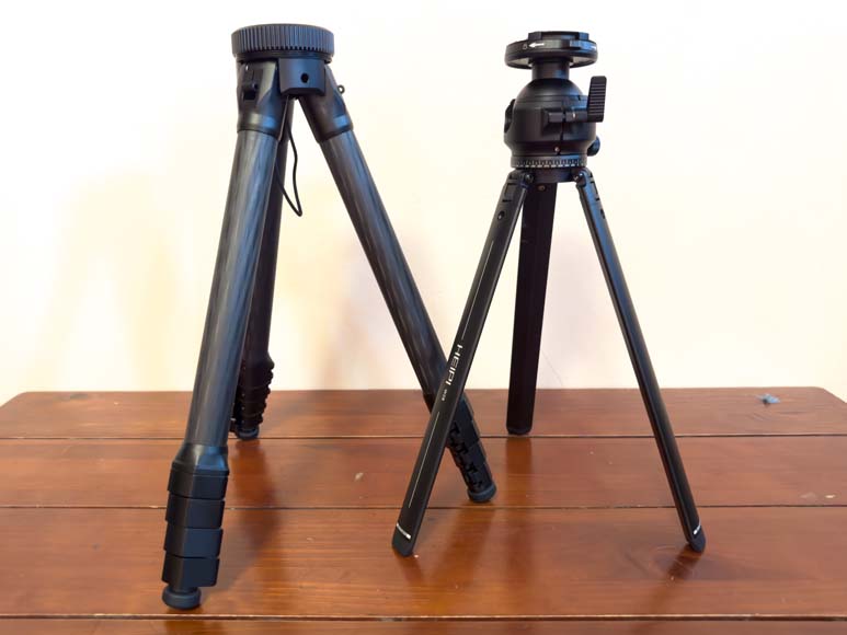 Two tripods on top of a wooden table.