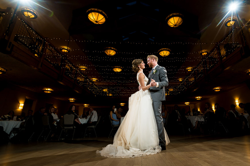 A bride and groom sharing their first dance in a large room.