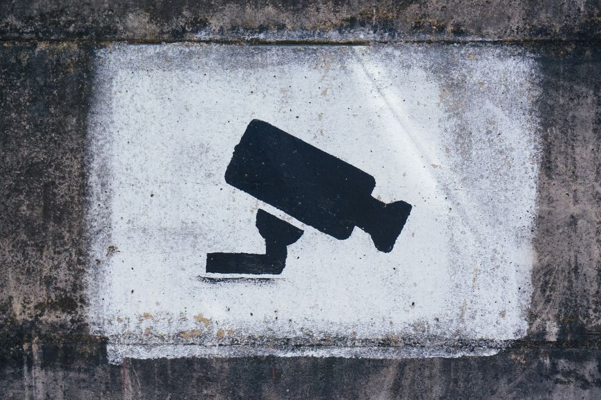 A cctv camera is painted on a concrete wall.