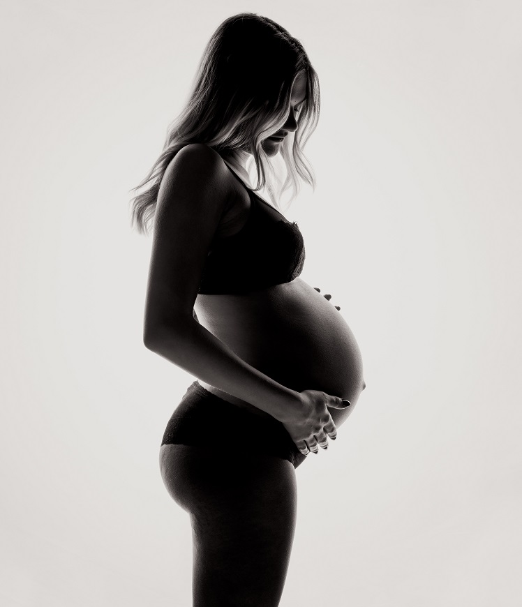 A pregnant woman is silhouetted against a white background.