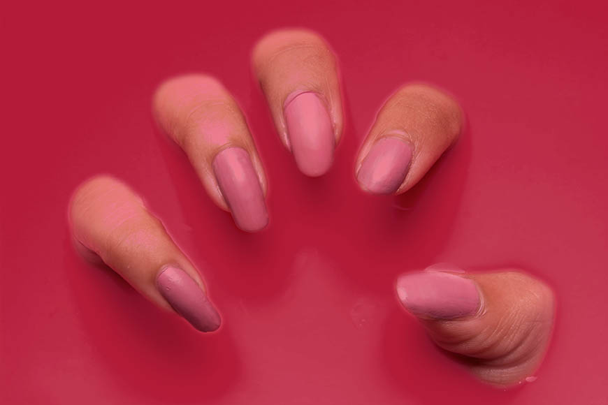 A woman's pink nails on a red background.