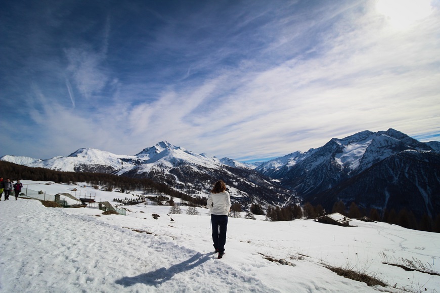 A woman is standing on a snow covered mountain.
