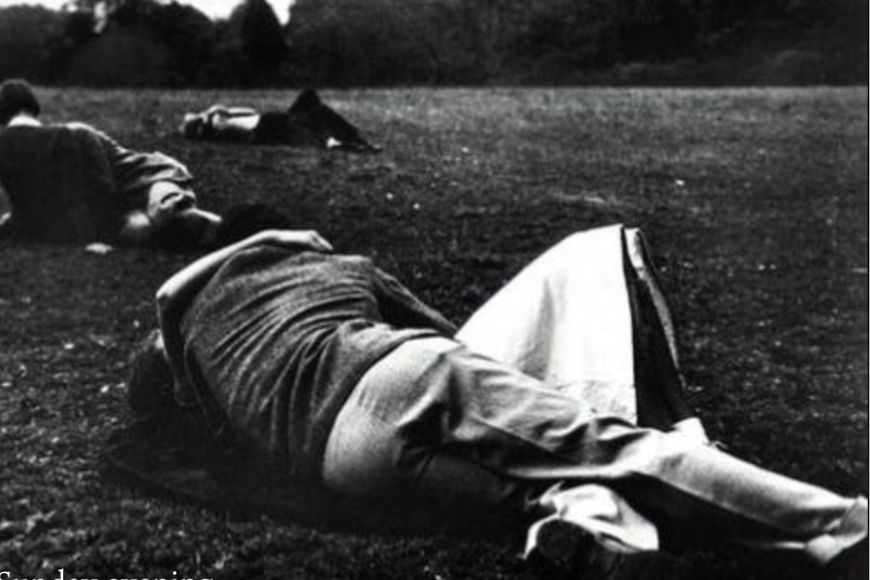 A black and white photo of people laying on the ground.
