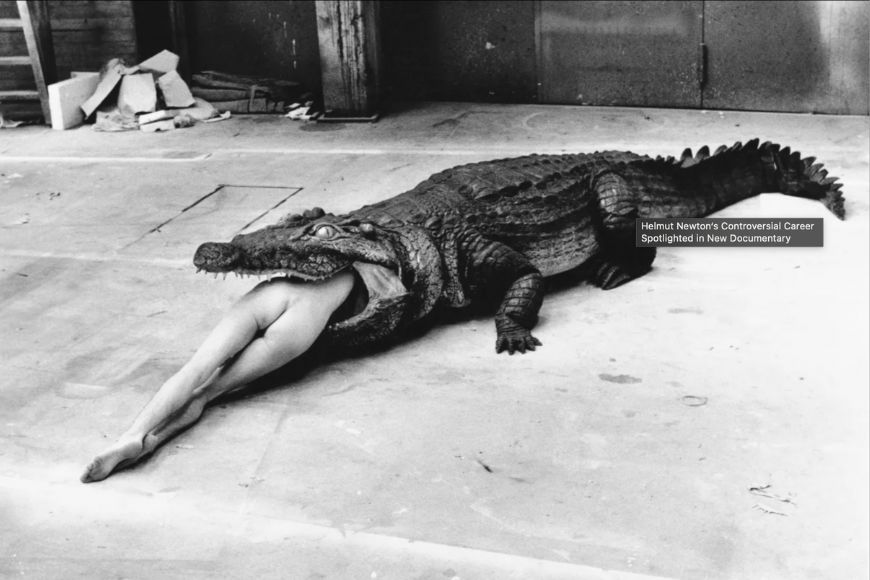 A woman laying on top of a crocodile.
