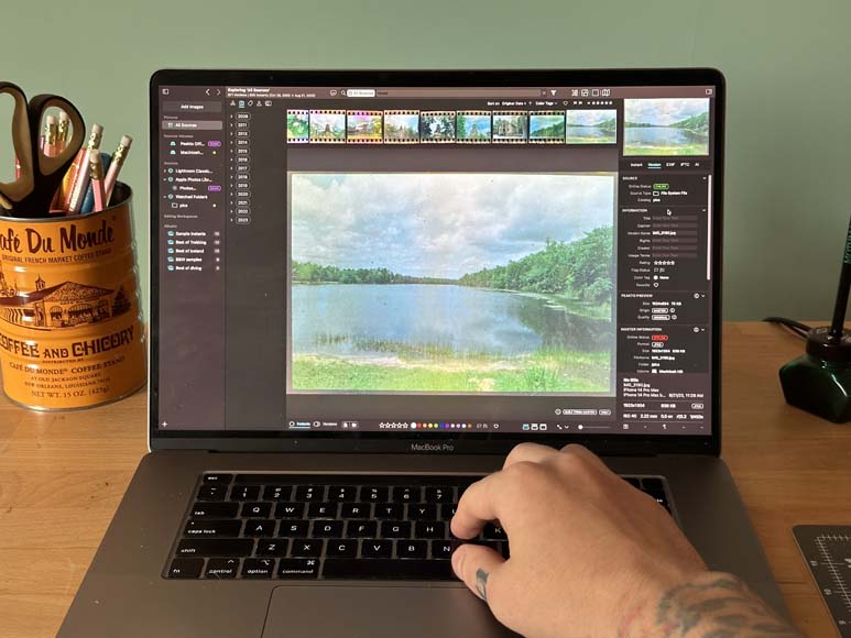 A person using a laptop to edit a photo.