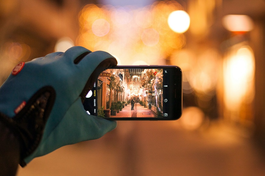 A person is taking a picture of a city at night.