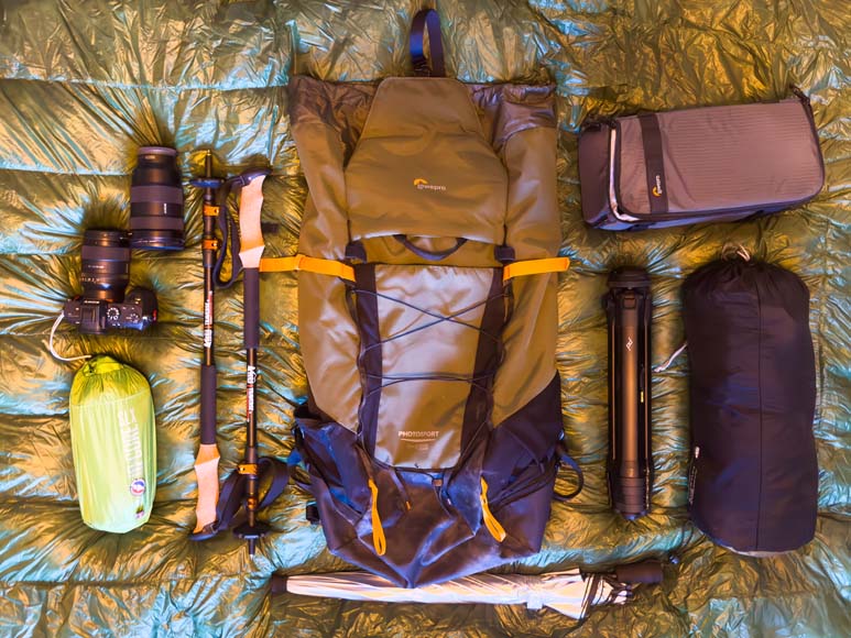 The contents of a backpack laid out on a bed.