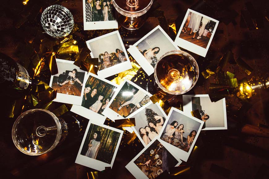 A table full of polaroid photos and champagne glasses.