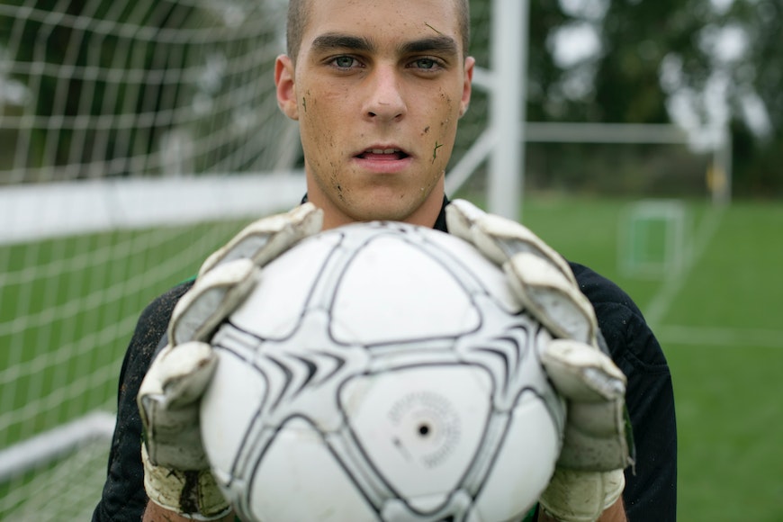 A young man holding a soccer ball.