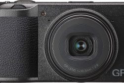 A black digital camera with a lens on it.
