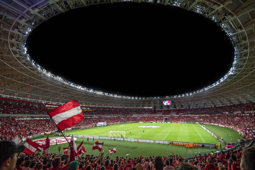 A soccer stadium full of people waving red and white flags.