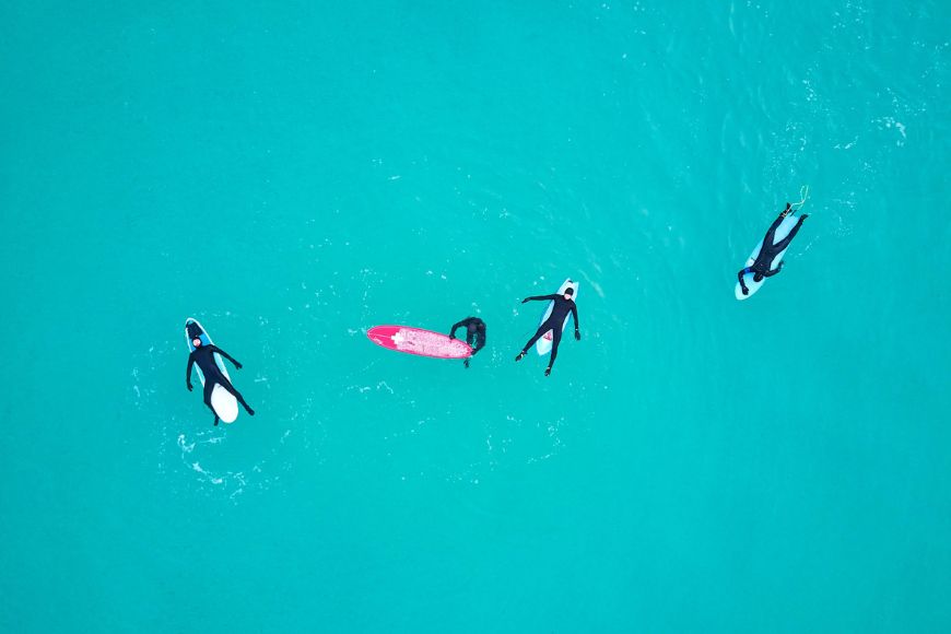Aerial view of a group of surfers in the ocean.