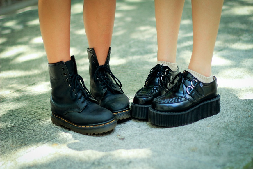 Two women wearing black dr martens shoes.