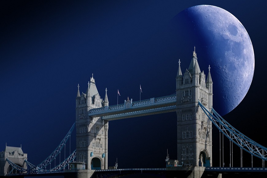 Tower bridge in london with the moon in the sky.