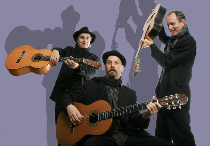 A group of men with guitars in front of a purple background.