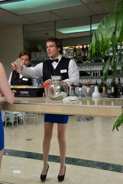 A bartender serving a woman at a restaurant.