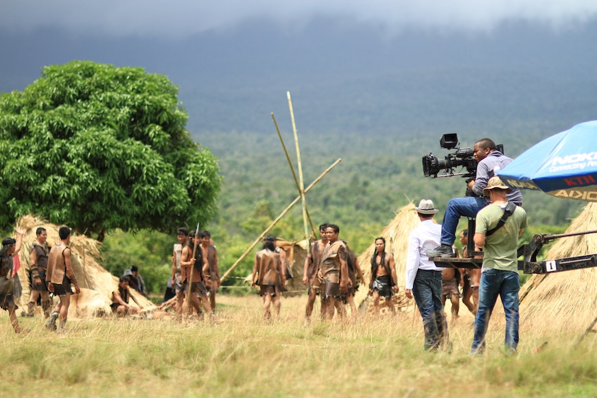 A group of people standing in a field with a camera.