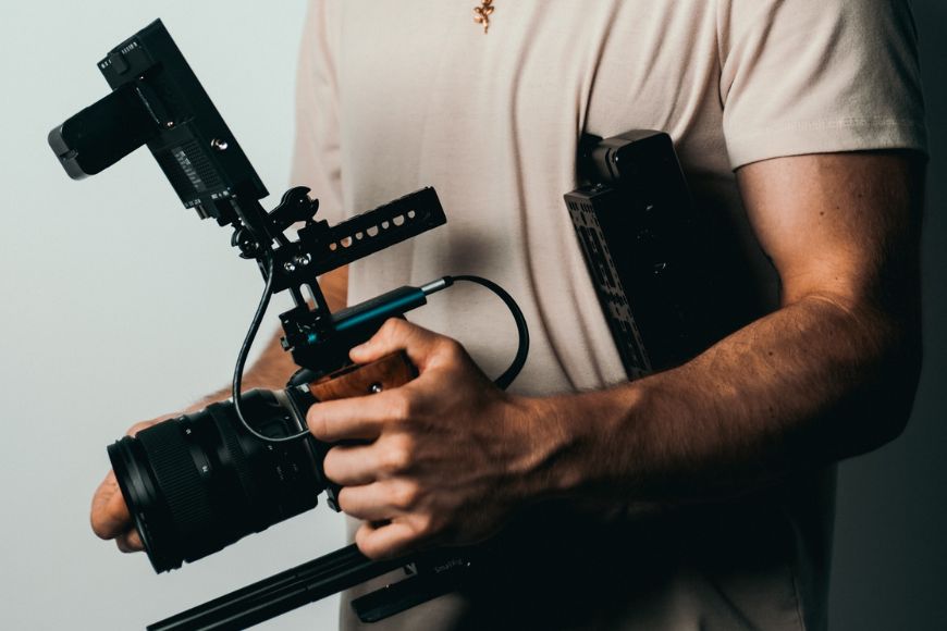 A man holding a camera and a tripod.