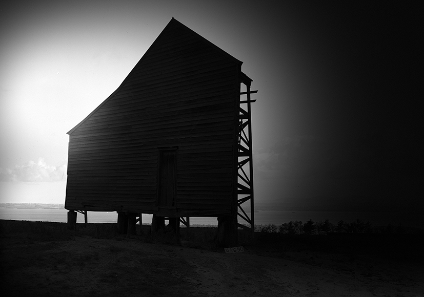 A black and white photo of a wooden building.