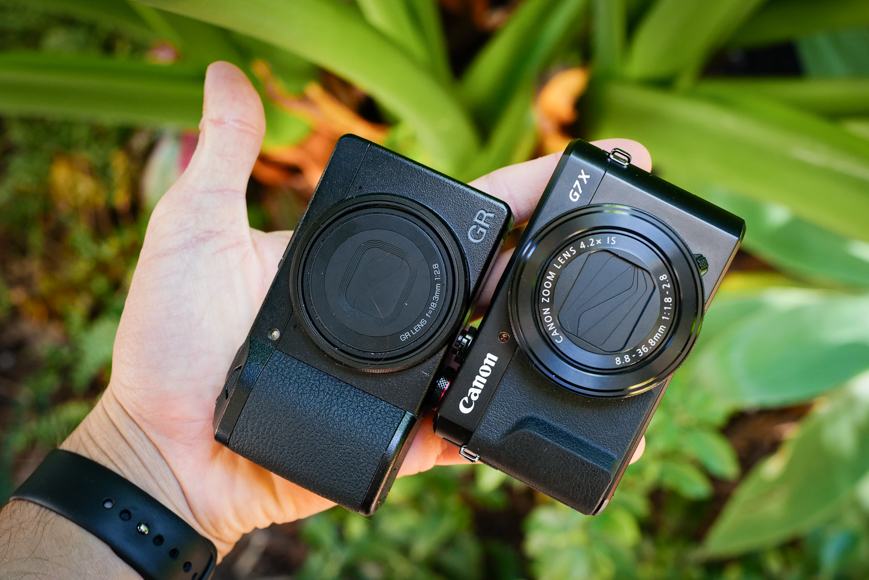 ricoh gr iii and canon G7x compact cameras in hand
