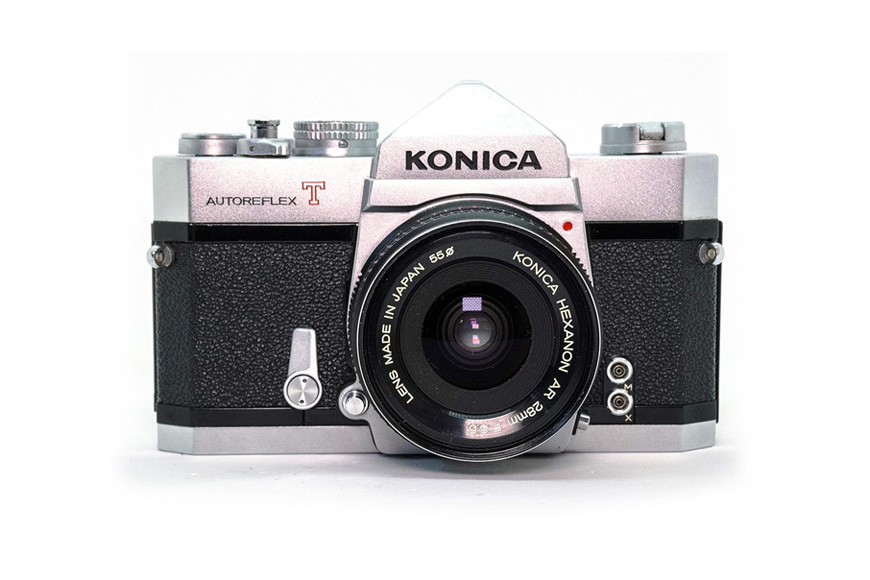 A camera with a silver lens on a white background.