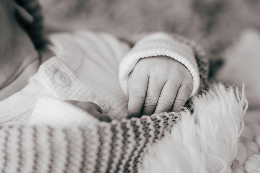 A black and white photo of a baby wrapped in a blanket.