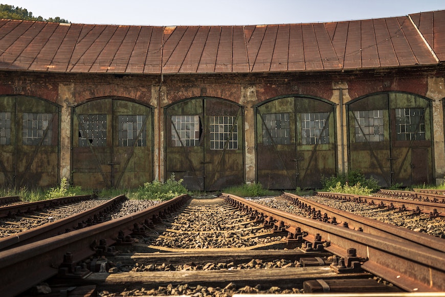 An abandoned train track with rusty doors.