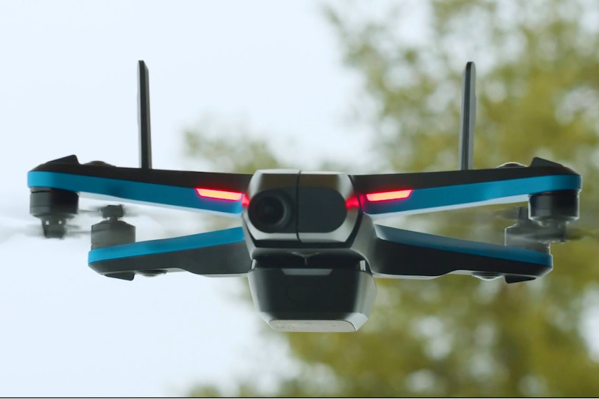 A blue and black drone flying in the air.