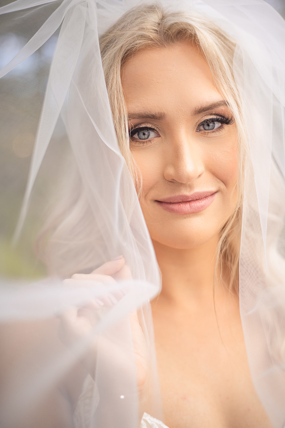A beautiful bride with a veil posing for a photo.