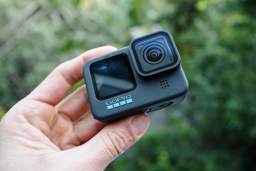 A person holding up a gopro hero 4 black.