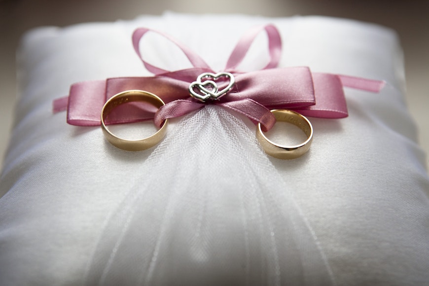 Two wedding rings on a pillow.