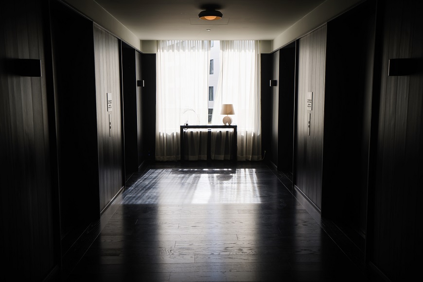 A dark hallway with a light shining in it.