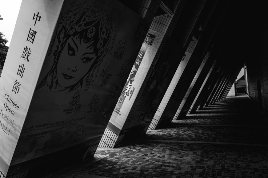 A black and white photo of a hallway with posters.