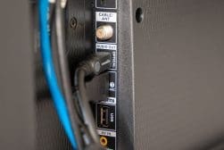 A close up of a tv with a blue cable connected to it.