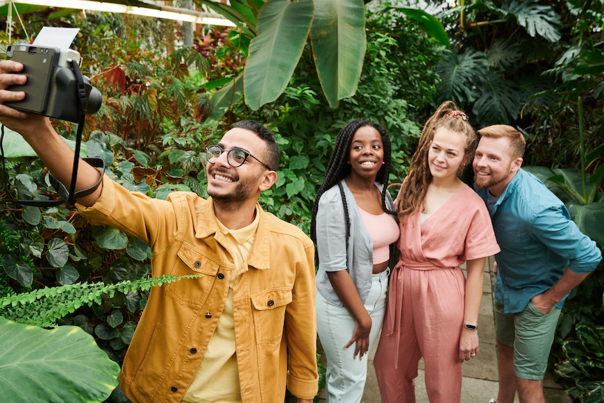 A group of people taking a picture in a greenhouse.