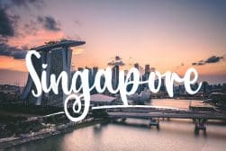 The city of singapore at sunset with the word singapore written on it.