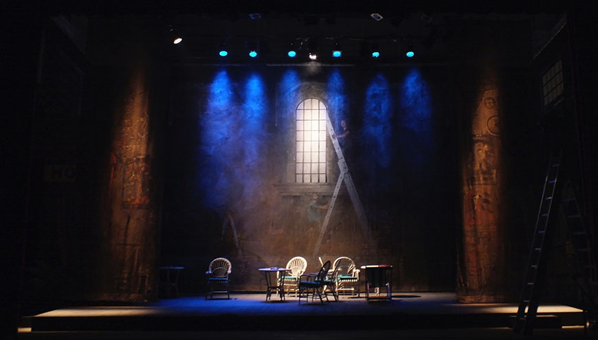 A stage set with chairs and a blue light.