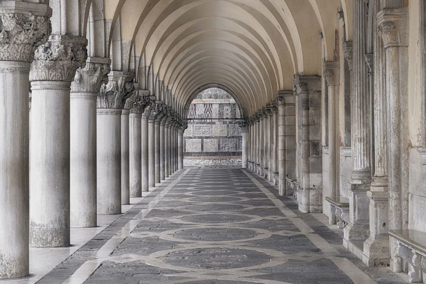 A hallway with columns and arches in italy.
