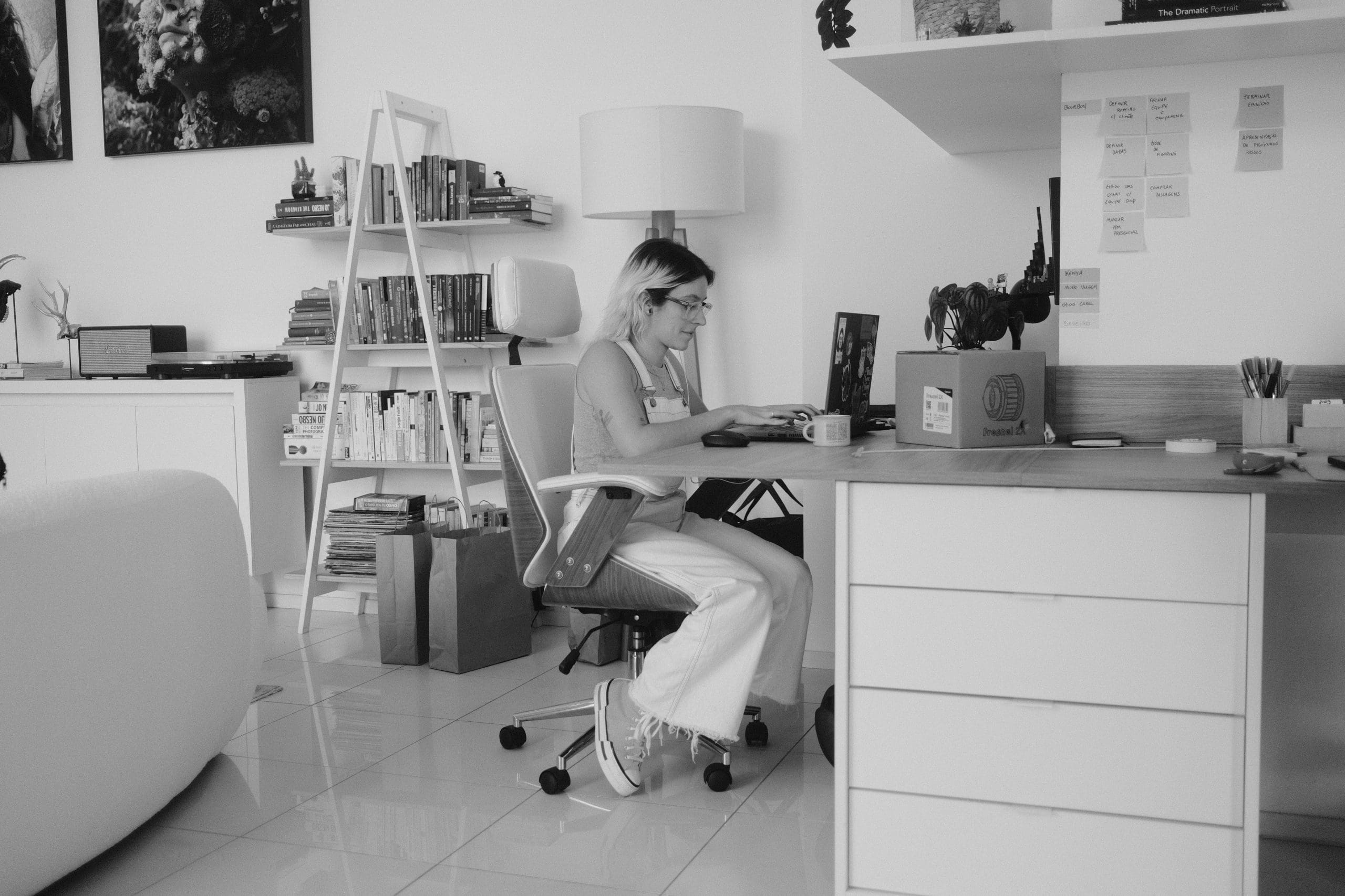Black and white photo of a woman working in her home office.