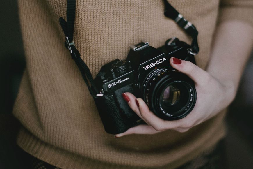 A woman holding a camera in her hands.