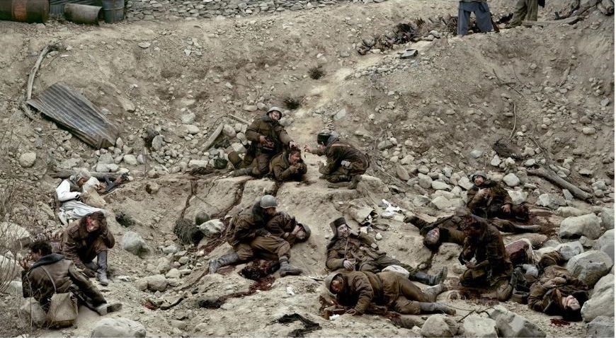 A group of soldiers are laying on the ground.