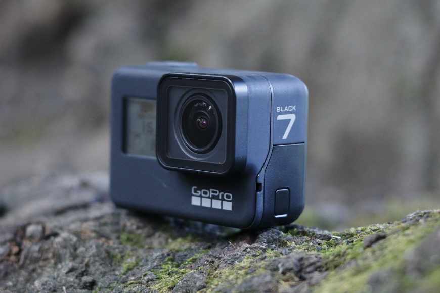 The Gopro hero 7 black sits on top of a tree trunk.