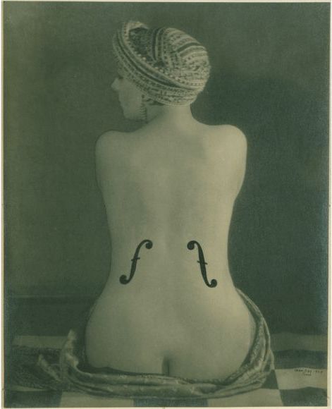 An old photo of a woman with a violin on her back.