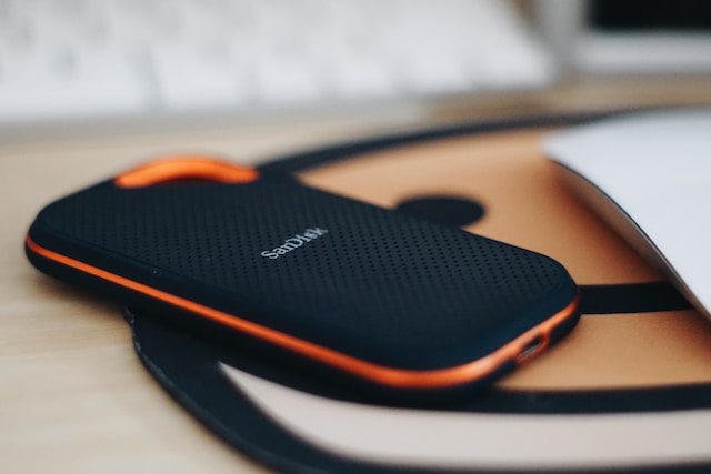 An orange and black phone case on a desk.