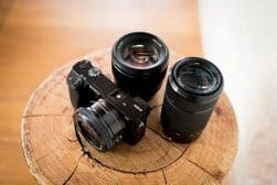 sony a6000 surrounded by lenses on a wooden post