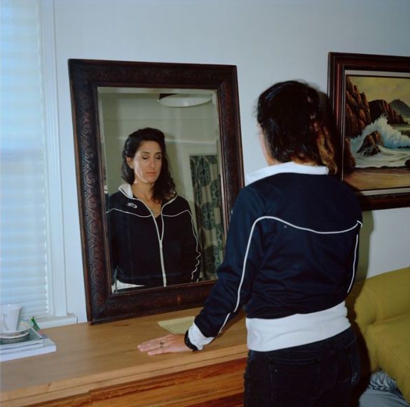 A woman standing in front of a mirror.