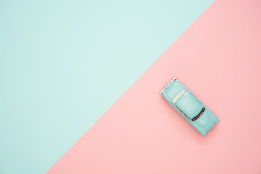 A blue car on a pink and blue background.