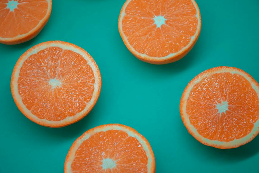 Sliced oranges on a green background.
