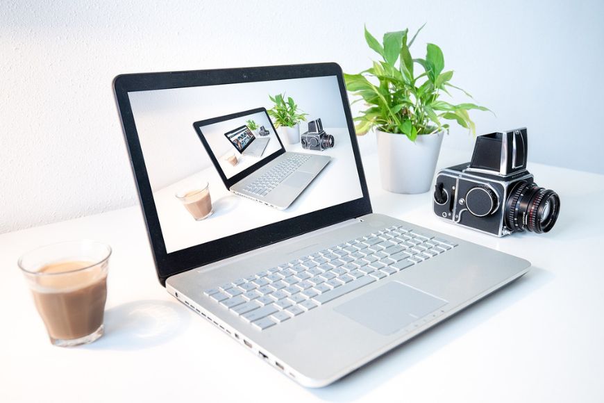A laptop computer with a camera on it on a white table.