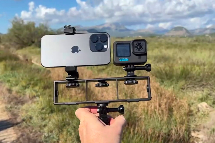 A person holding up an iphone and a gopro.